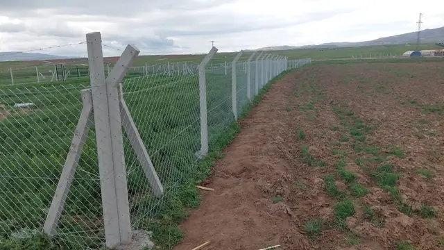 Tarla kenarında payandalı beton köşe direği ve gerdirilmiş tel örgü