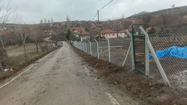 Köy yolu kenarında payandalı beton direklerle çekilmiş tel örgü