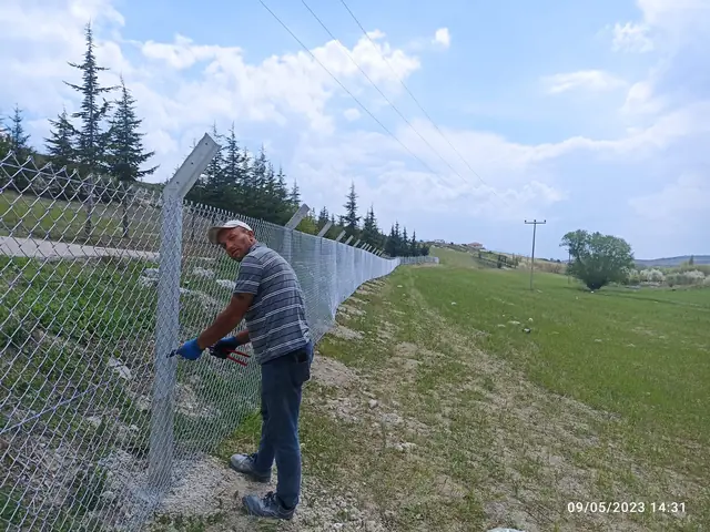 Doğanay ustası beton direkli galvaniz tel örgüyü gergi teline bağlıyor